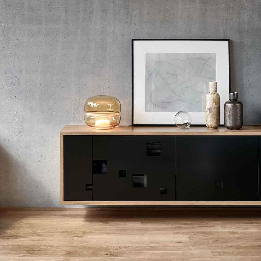 Brokis Tischlampe Macaron S auf einem modernen Sideboard mit Kunst und Dekoration.