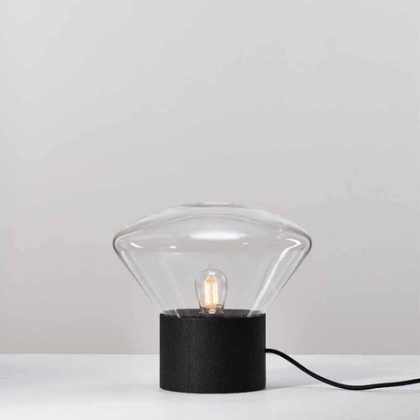 Brokis table lamp Muffins Wood 01 on a table with a glass shade and wooden base.