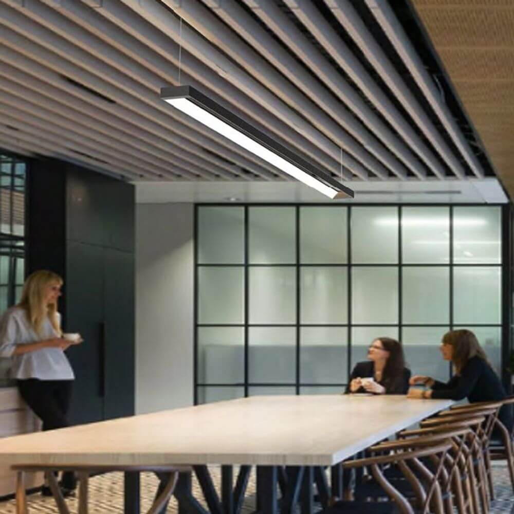 Innovative schwarze LED Pendel-Schreibtischleuchte mit verstellbaren Lichtfarben über einem modernen Konferenztisch.