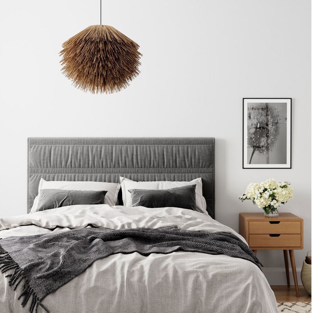 Bali Hängeleuchte aus Bambusstroh über einem modernen Schlafzimmerbett mit neutraler Bettwäsche.