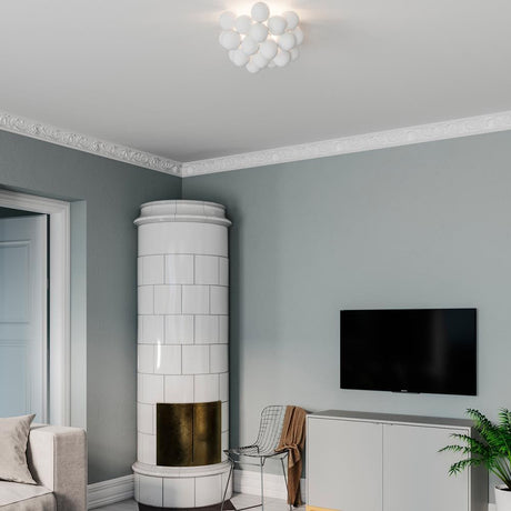 Taklampa Gross Ø 50 cm i stilfullt vardagsrum med öppen spis och modern TV.