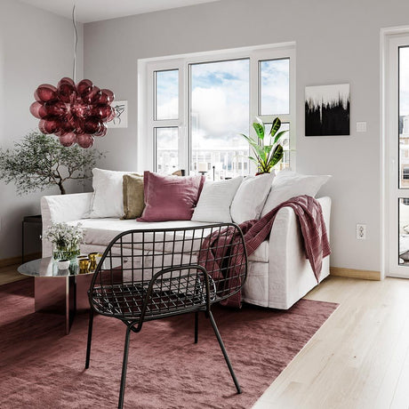 Ambiente moderno con lampada a sospensione in vetro Gross Ø 50cm sopra un divano bianco e mobili di stile.