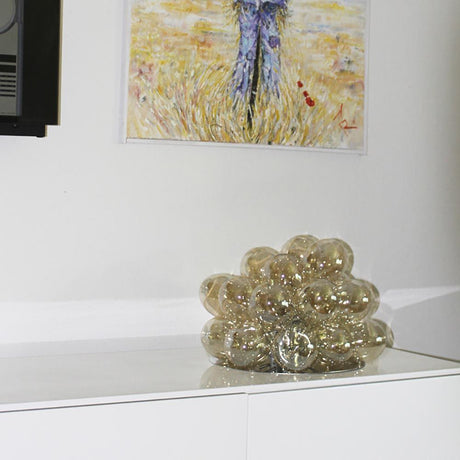 Large glass table lamp Ø 38cm amber on a table with artwork in the background