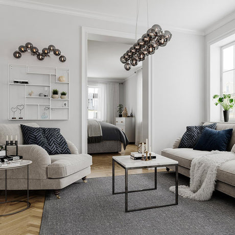 Lampada a sospensione Splendor Bar 124 cm in un soggiorno moderno sopra il tavolino da salotto.