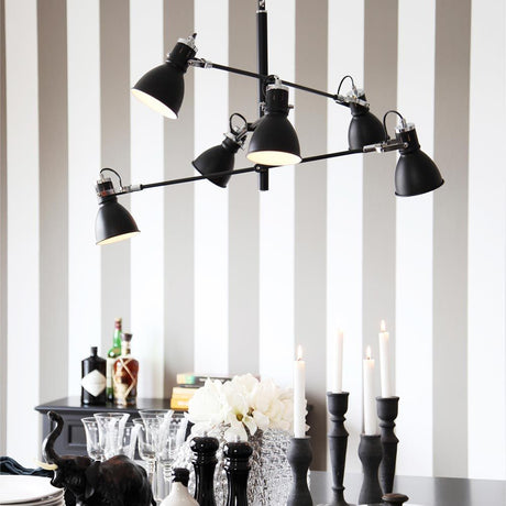 Pendant light Pigalle 6-light Black above a dining table with decoration and candles.