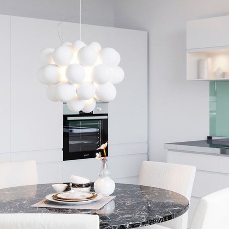 Grande lampada a sospensione in vetro Gross Ø 50 cm bianca sopra un elegante tavolo da pranzo in una cucina moderna.