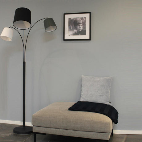 Foggy floor lamp, 3-light, 175 cm, next to a cosy armchair in a modern room design.