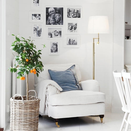 Orlando floor lamp 138 cm with LED reading arm next to a cozy armchair in the living area.