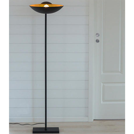 Captain floor lamp direct or indirect black gold-colored in a modern interior with a warm light glow.