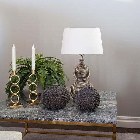 Lampada da tavolo Lofty in stile orientale su un tavolo con candele, piante e oggetti decorativi.