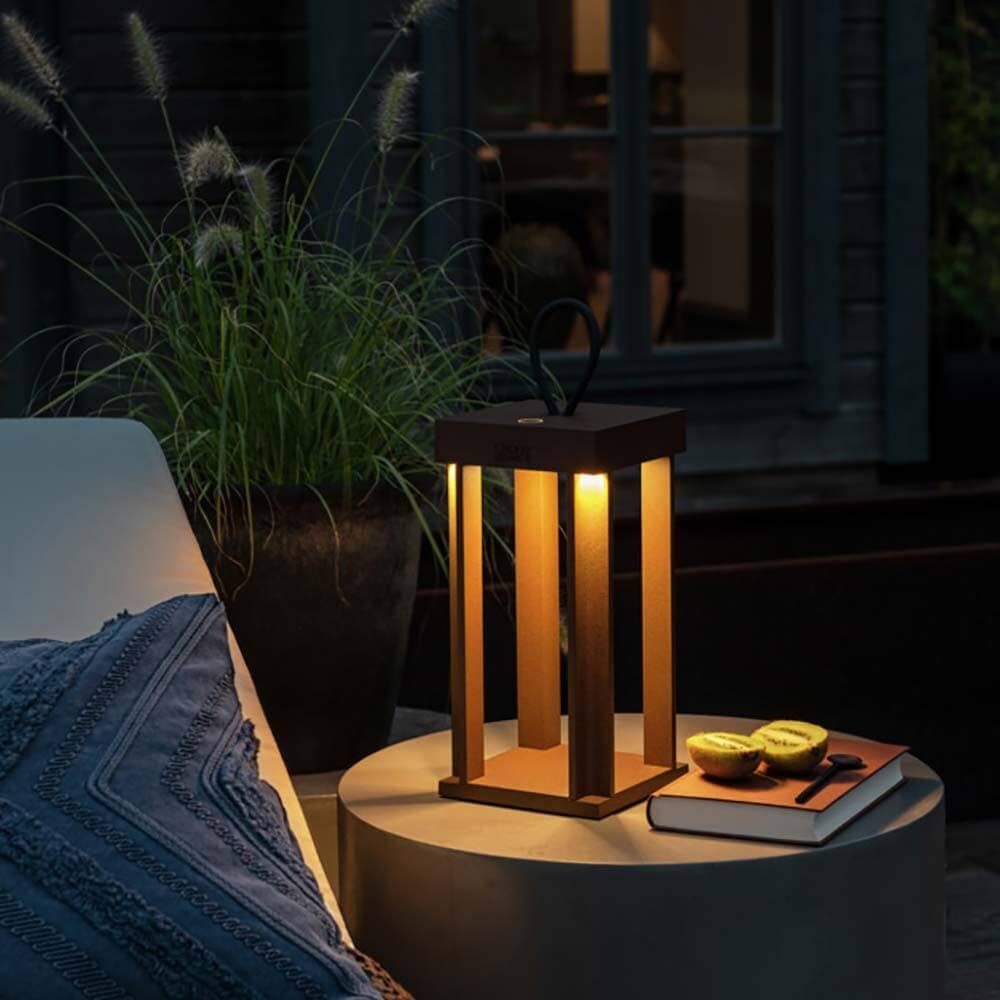 Cannes Outdoor USB-Laterne IP54 auf einem Tisch im Freien, stimmungsvolle Akkuleuchte mit warmem Licht.