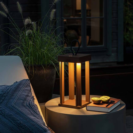 Cannes Outdoor USB-Laterne IP54 auf einem Tisch im Freien, stimmungsvolle Akkuleuchte mit warmem Licht.