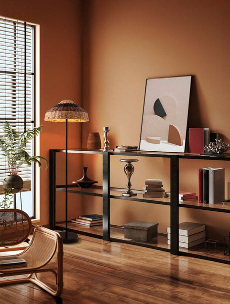 Lampadaire Caro noir et brun dans un intérieur moderne avec bibliothèque et œuvre d’art.