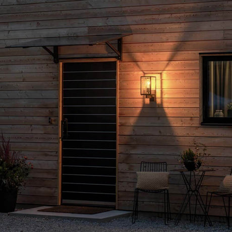 Carpi wall light lantern mounted on a wooden façade, creates atmospheric lighting at the entrance.