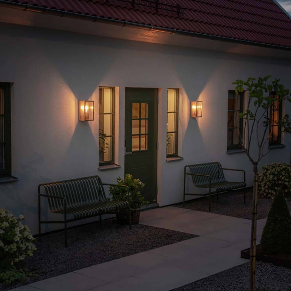 Carpi Wandleuchte Stahl IP44 an einer Wand in einem modernen Eingangsbereich bei Nacht.