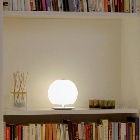 Casablanca Tischleuchte Ball Mini auf einem Regal mit Bücher und Dekoration, sorgt für stimmungsvolles Licht.