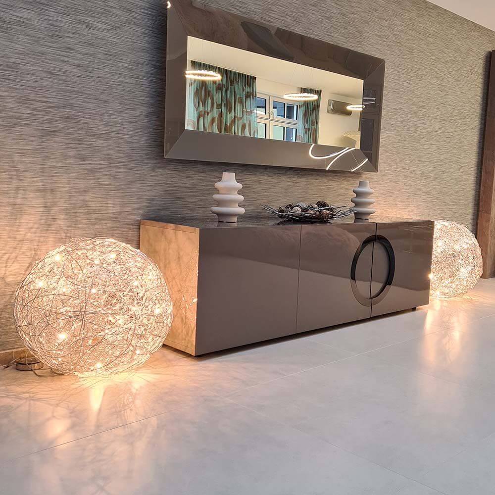 Catellani & Smith Fil de Fer F LED Bodenleuchte Drahtkugel Dimmbar neben einem modernen Sideboard mit Spiegel.