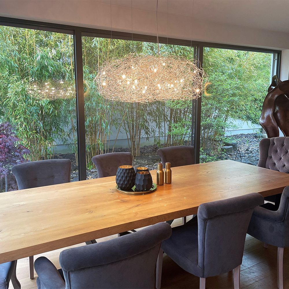 Modernes Esszimmer mit Catellani & Smith Fil de Fer Nuvola LED Hängeleuchte und eleganten grauen Stühlen.