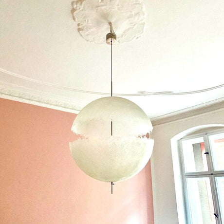 Catellani & Smith PostKrisi 66 LED Hängeleuchte Ø 60cm in modernem Innenraum mit rosa Wand.