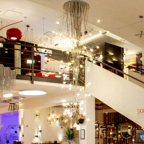 Suspension Catellani & Smith Turciù 36 LED 160 cm Flex dans un intérieur moderne avec des lumières scintillantes.