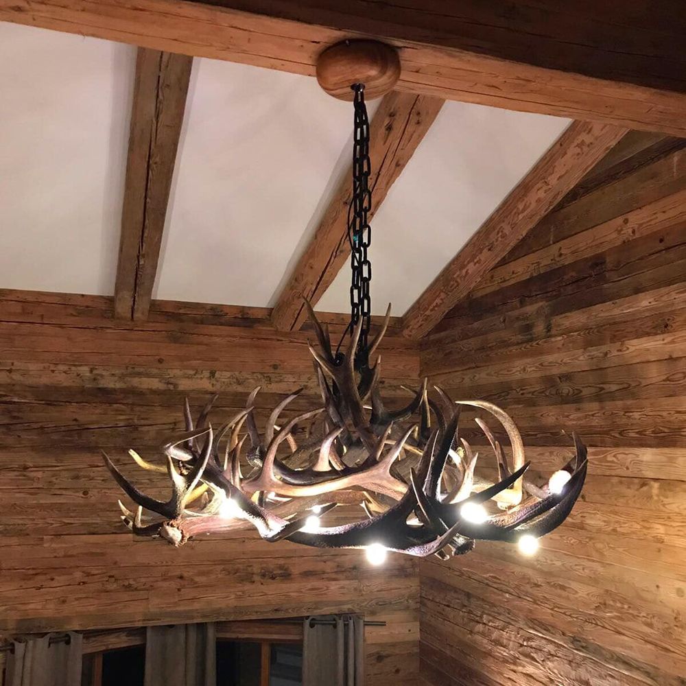 Chalet Hirschgeweihlampe Ø 120cm als stilvolle Deckenleuchte aus echten Geweihen in Holzraum.