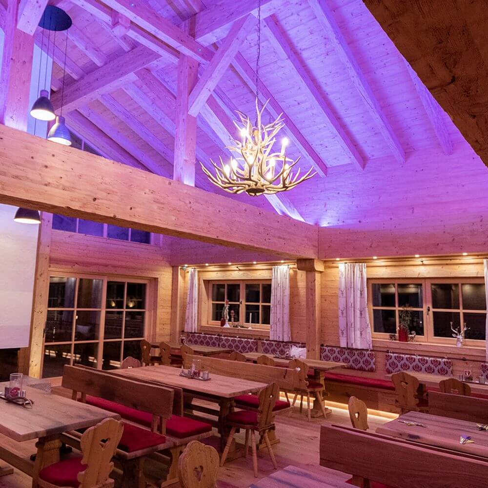 Chalet XL Holz Geweih-Lüster Ø 100cm 12-flammig im rustikalen Innenraum mit Holzdecke und stimmungsvollem Licht.