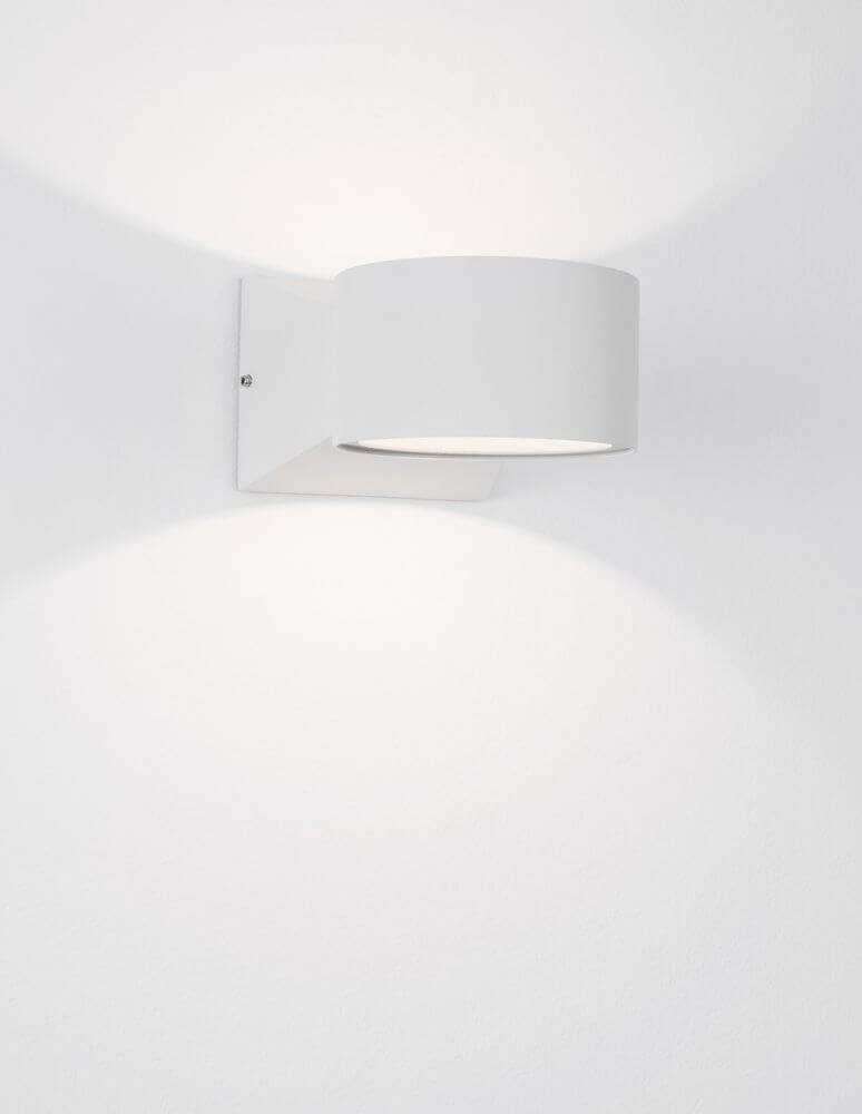 Chez LED Außenwandleuchte Ø 9cm 3000K Weiß IP54 an Wand montiert, strahlt warmweißes Licht aus.