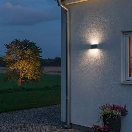 Chieri LED outdoor wall light anthracite, opal acrylic glass on a house wall at dusk.