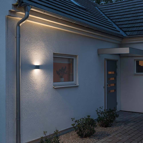 Chieri LED outdoor wall light anthracite, opal acrylic glass mounted on a house wall at dusk.