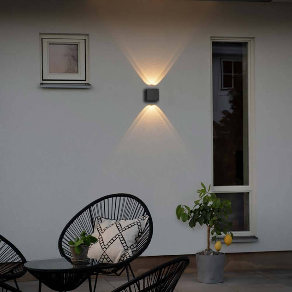 Chieri LED Wandleuchte Up & Downlights an einer Wand im Außenbereich mit warmem Licht.