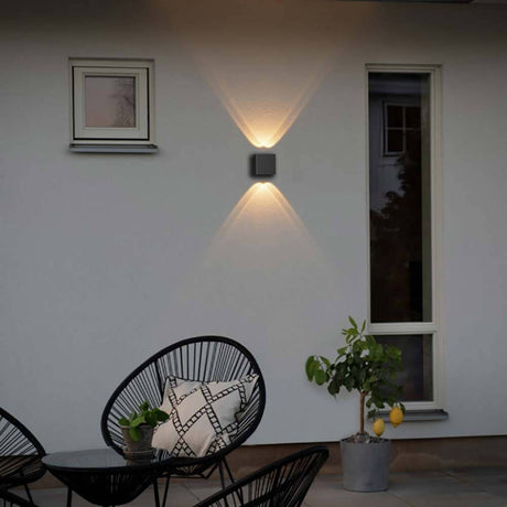 Chieri LED Wandleuchte Up & Downlights an einer Wand im Außenbereich mit warmem Licht.