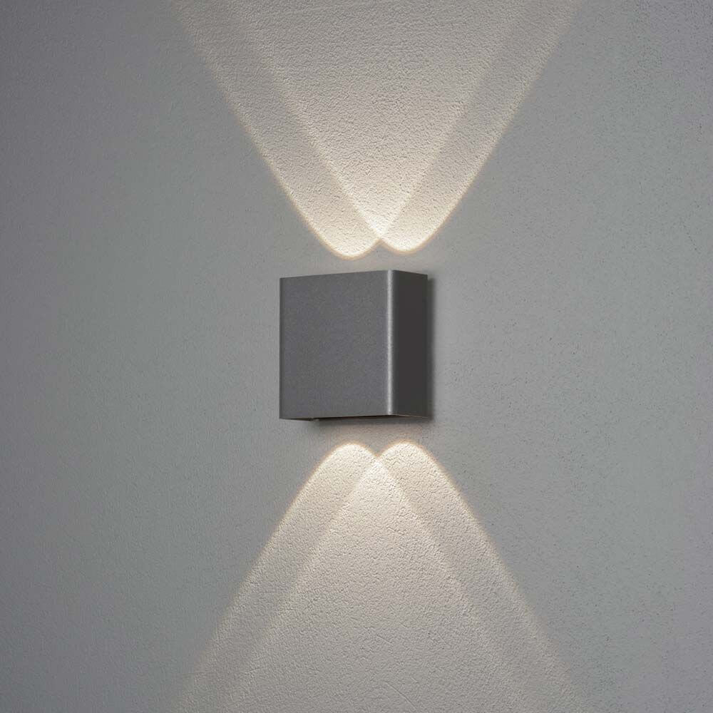 Chieri LED Wandleuchte Up & Downlights an einer Wand, strahlend in grauem Design.