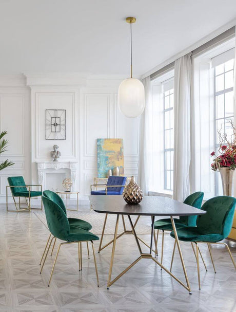 Moderne interiør med Chrysi pendel lys guld, hvid over et elegant bord og stilfulde stole.