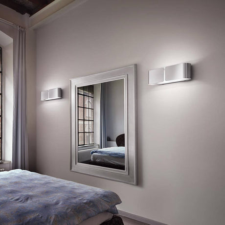 Applique Clip Up&Down 44 cm bianca sulla parete accanto a uno specchio sopra un letto.
