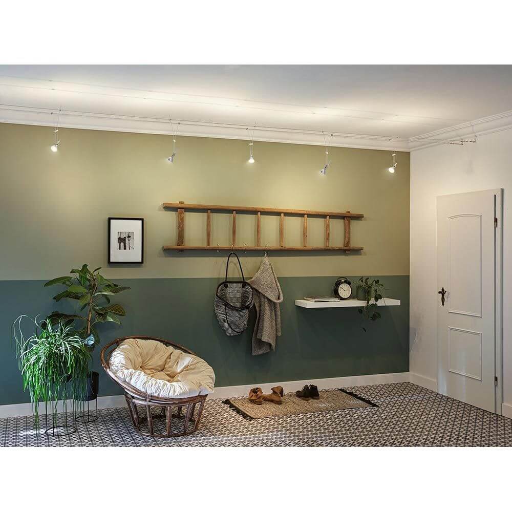 Wohnraum mit CorDuo Seilsystem und Einzelspot, stilvoller Look mit Pflanzen und Dekoration.