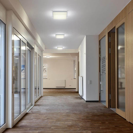Cosi LED ceiling light L nickel-matte in a modern hallway with window fronts and wooden details.