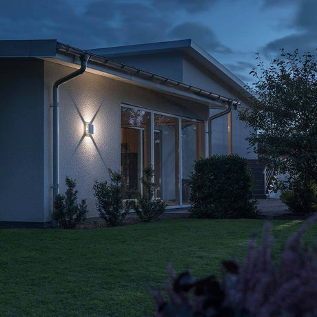 Cremona LED Außen-Wandleuchte 4er-Lichtstrahl einstellbar Weiß an einer modernen Hauswand im Garten bei Nacht.