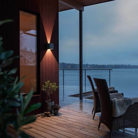 LED utendørs vegglampe Cremona justerbart lysutslipp antrasitt på en moderne treveranda med utsikt over innsjøen.
