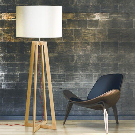 Cross Stehleuchte mit Holzfuß 160cm Weiß neben einem modernen schwarzen Sessel in einem eleganten Raum.