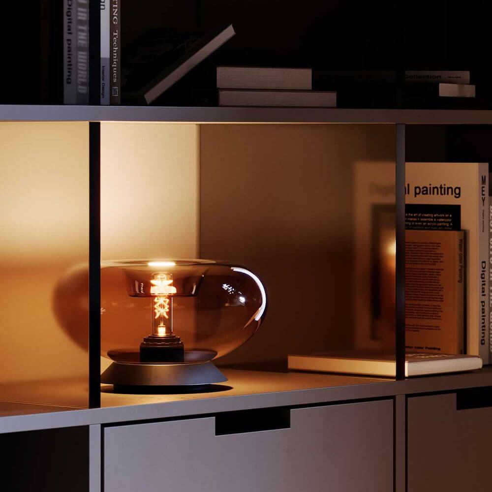 s.luce Cruet E27 Design Tischleuchte Glas mit Schalter auf einem Regal in modernem Ambiente.