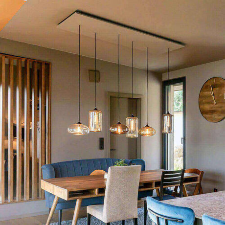 Moderne Esszimmerbeleuchtung mit hängenden Glaskugelleuchten über einem Holztisch und blauen Stühlen.