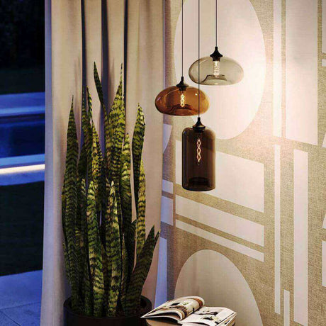 s.luce Cruet Glas-Pendelleuchte Up & Low in modernem Ambiente mit Pflanzen und Zeitschrift.