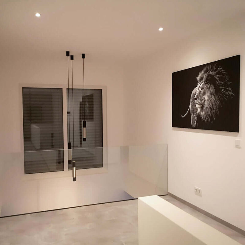 Elegantes Wohnzimmer mit moderner Ausstattung und Löwenportrait an der Wand, stilvolle Lichtakzente.