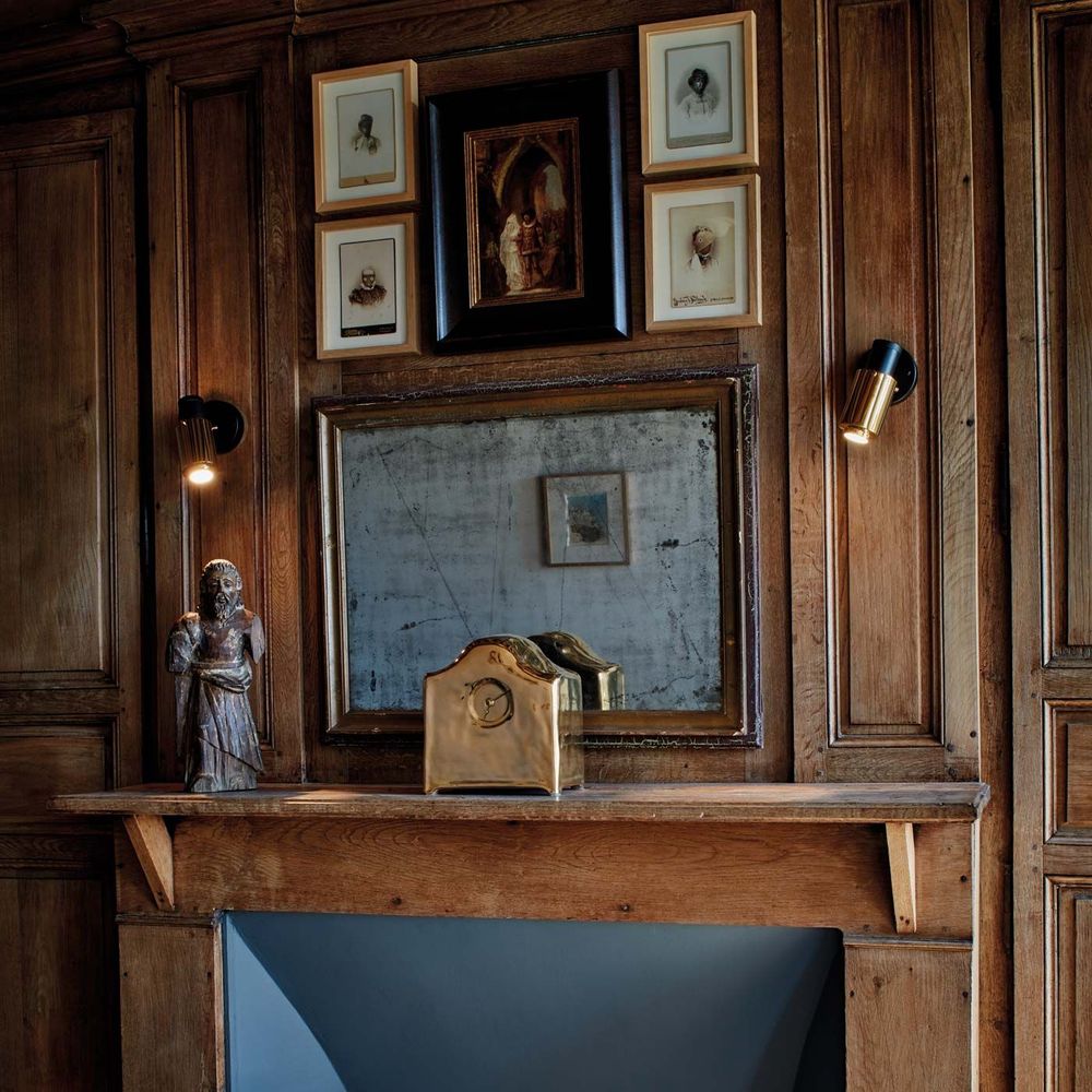 Wandleuchte Biny Spot von DCWéditions in einem eleganten Holzinterieur mit Bildern und Skulptur.