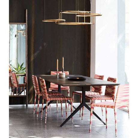 DCWéditions Broche LED-lysekrone i naturmessing over et elegant spisebord med stoler.