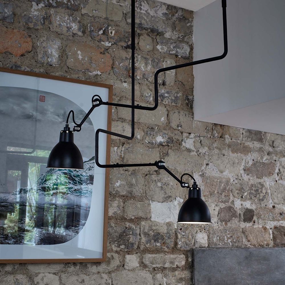 DCWéditions Gras N°312 Deckenlampe mit Ausleger in modernem Innenraum, elegantes Design an Steinwand.