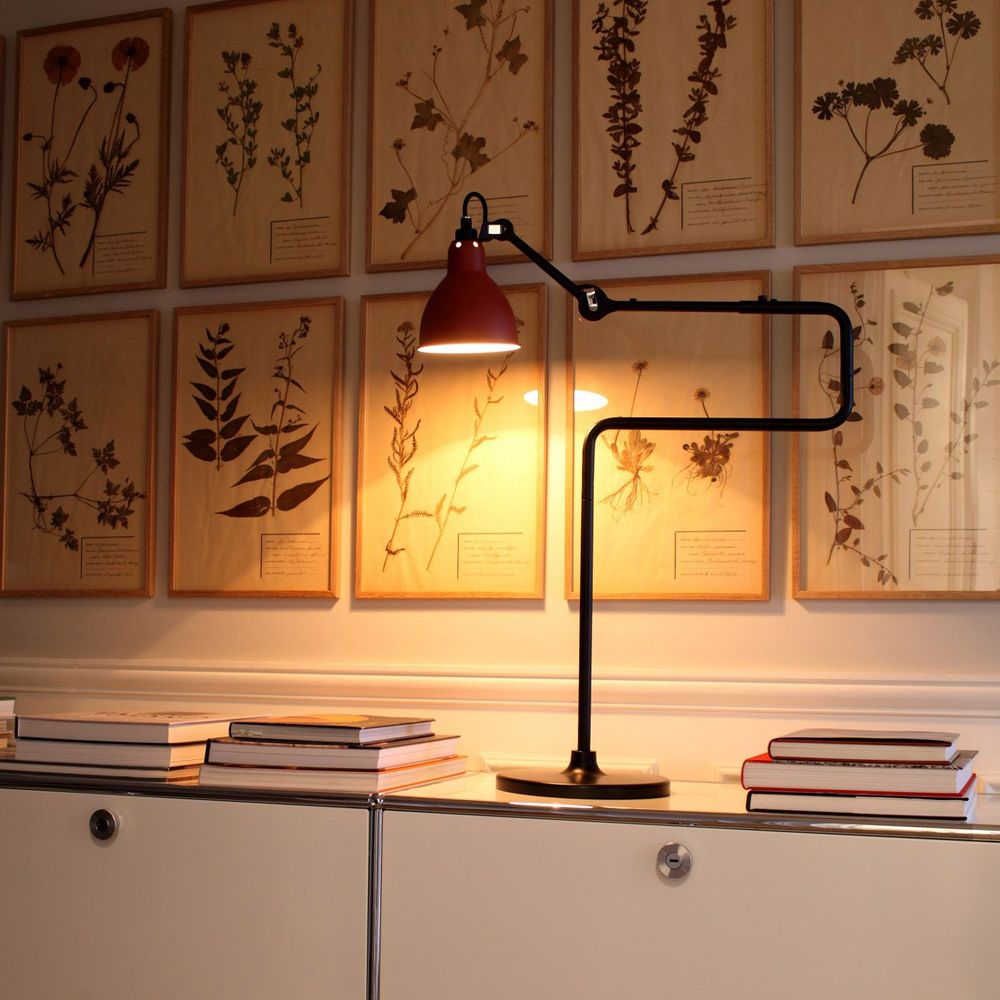 DCWéditions Gras N°317 Tischlampe mit Schirm schwenkbar auf einem Tisch, beleuchtet in einem eleganten Raum.
