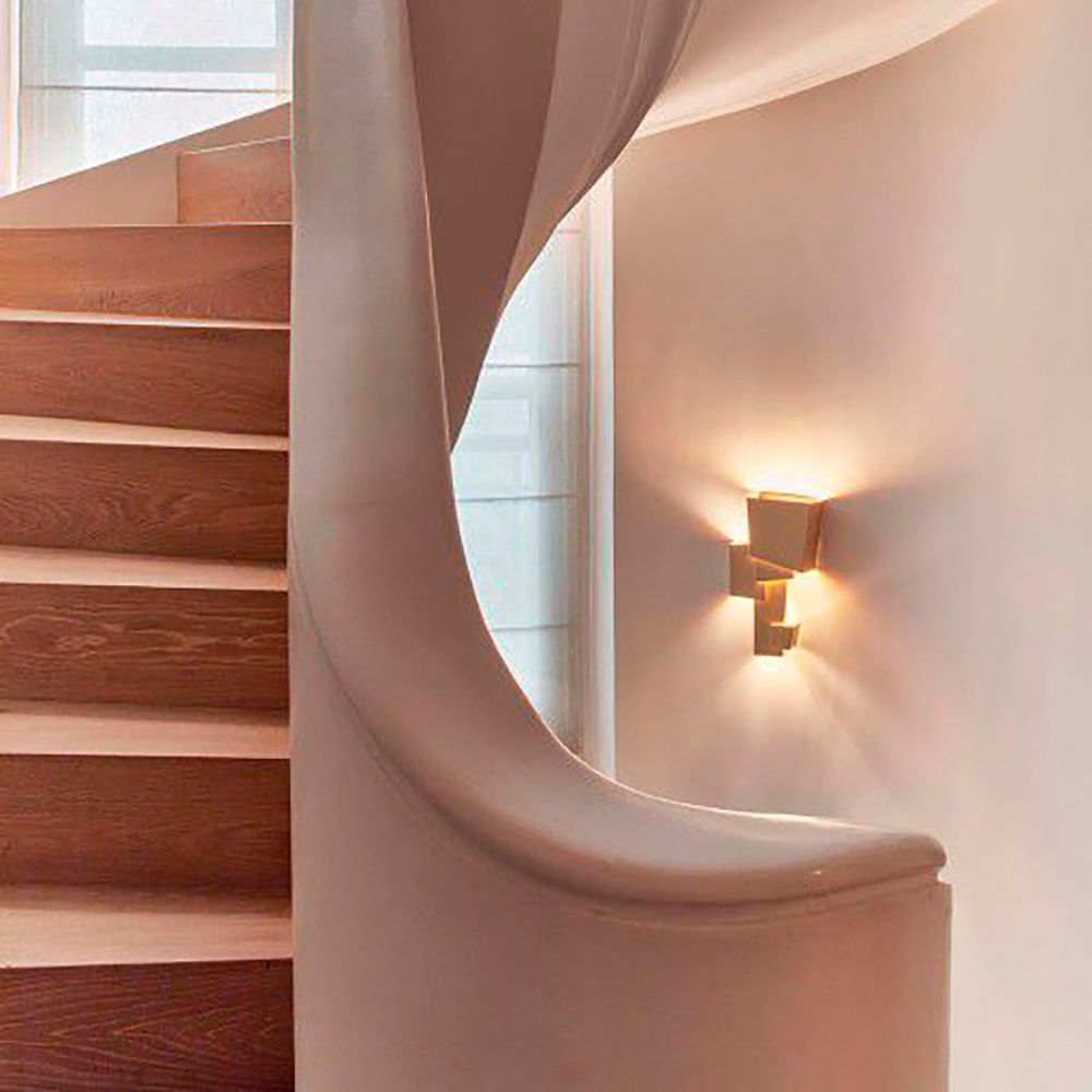 Geometrische DCWéditions Map 1 Wandleuchte an einer geschwungenen Treppe in modernem Interieur.