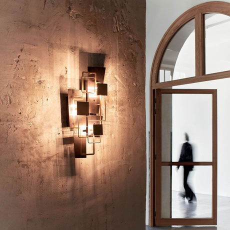 DCWéditions Map 2 Wandleuchte geometrisch an einer Wand, mit warmem Licht und modernen geometrischen Formen.