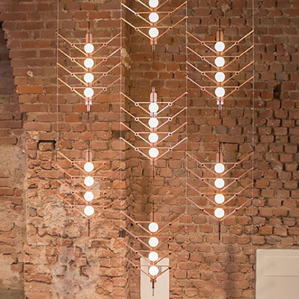 DCWéditions VVV Abhängung Baldachin für Module mit modernen Lichtdesigns an einer Backsteinwand.